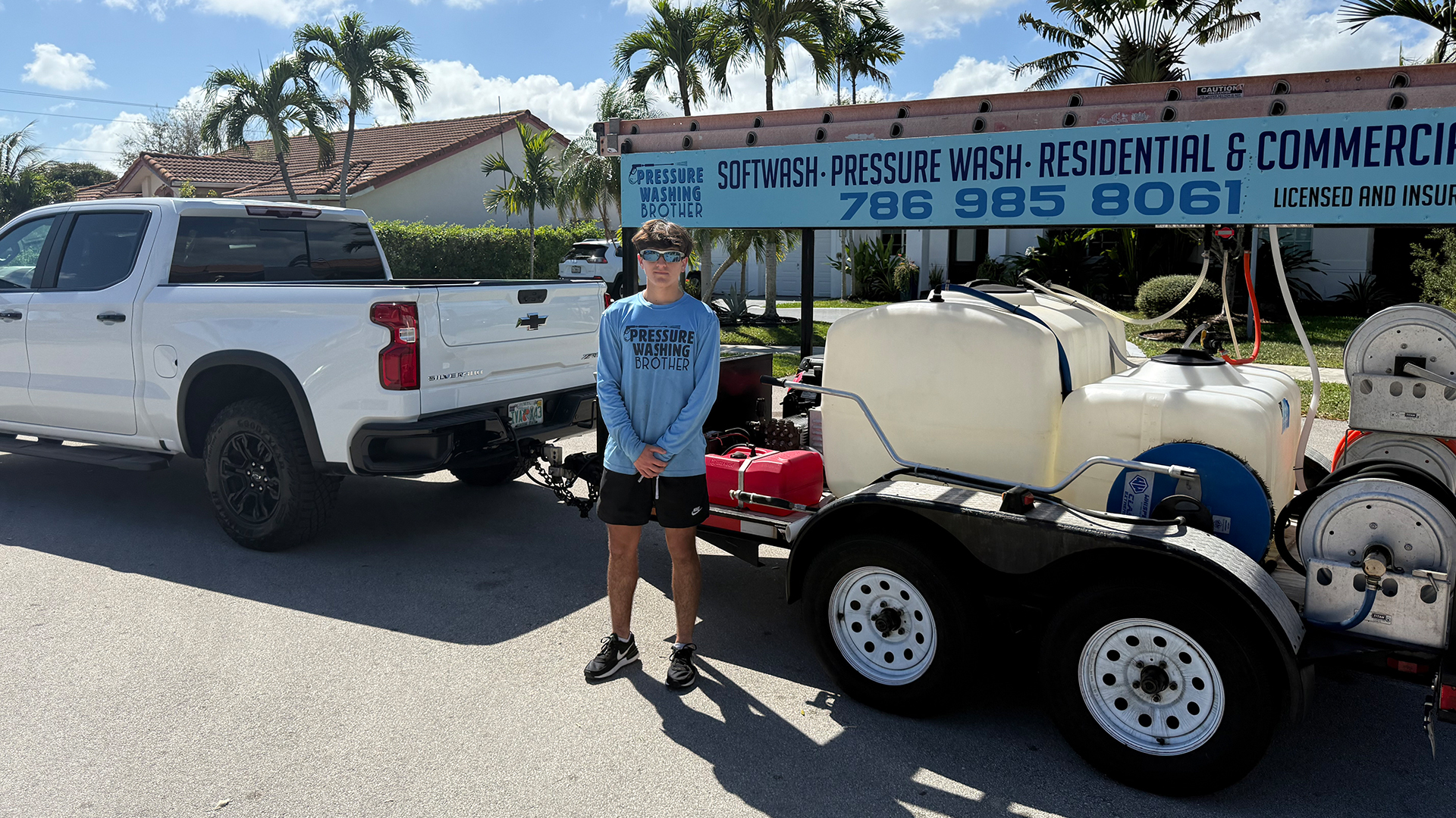 Pressure Washing Brother standing beside the company truck and soft-wash trailer